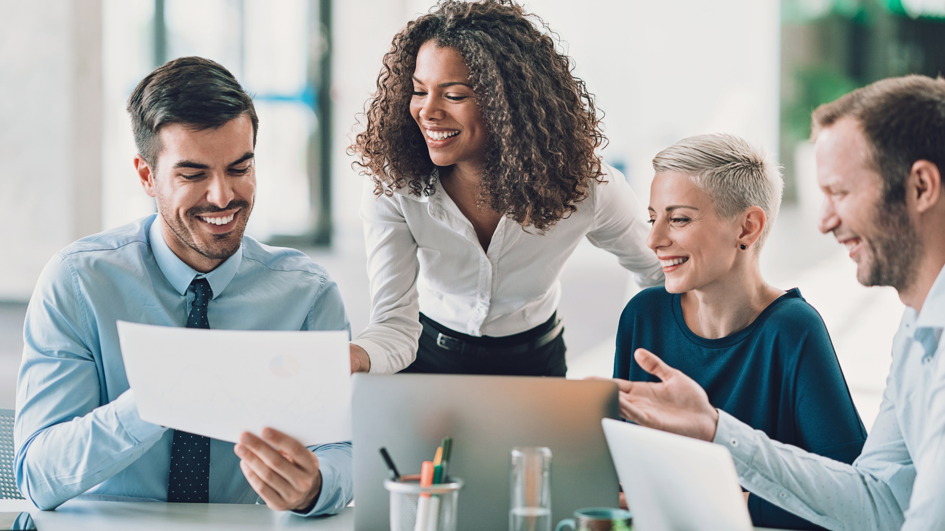 Business people talking around a table smiling