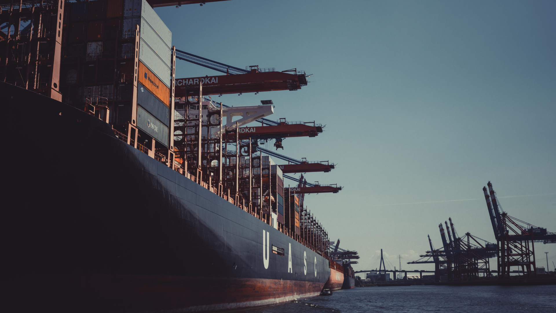 cargo ships at a dock at sunset